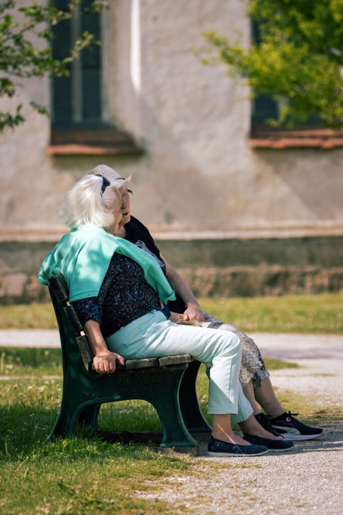 wo elderly women sitting on a bench enjoying a peaceful moment outdoors