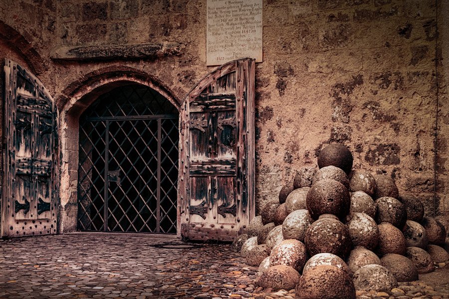 Pile of old cannonballs near historic doorway at Burghausen Castle in Bavaria, Germany