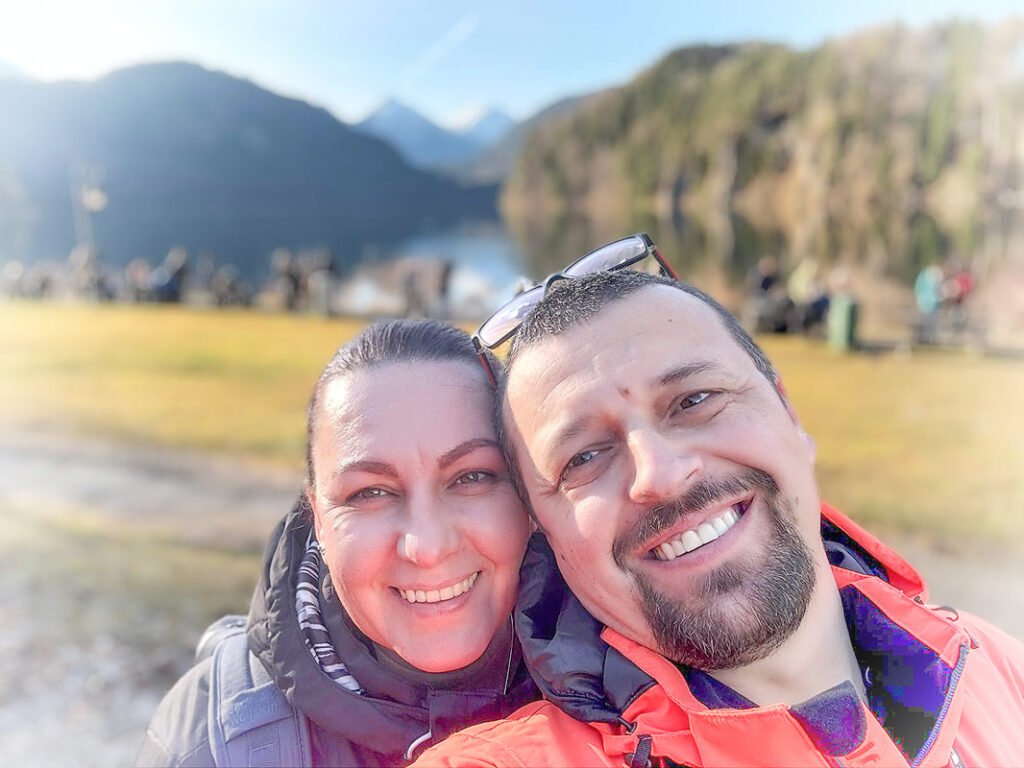 Cizme Skitaljke exploring Schwangau, Bavaria, showcasing stunning alpine mountains and a tranquil lake in the background – Travel & Explore Germany.