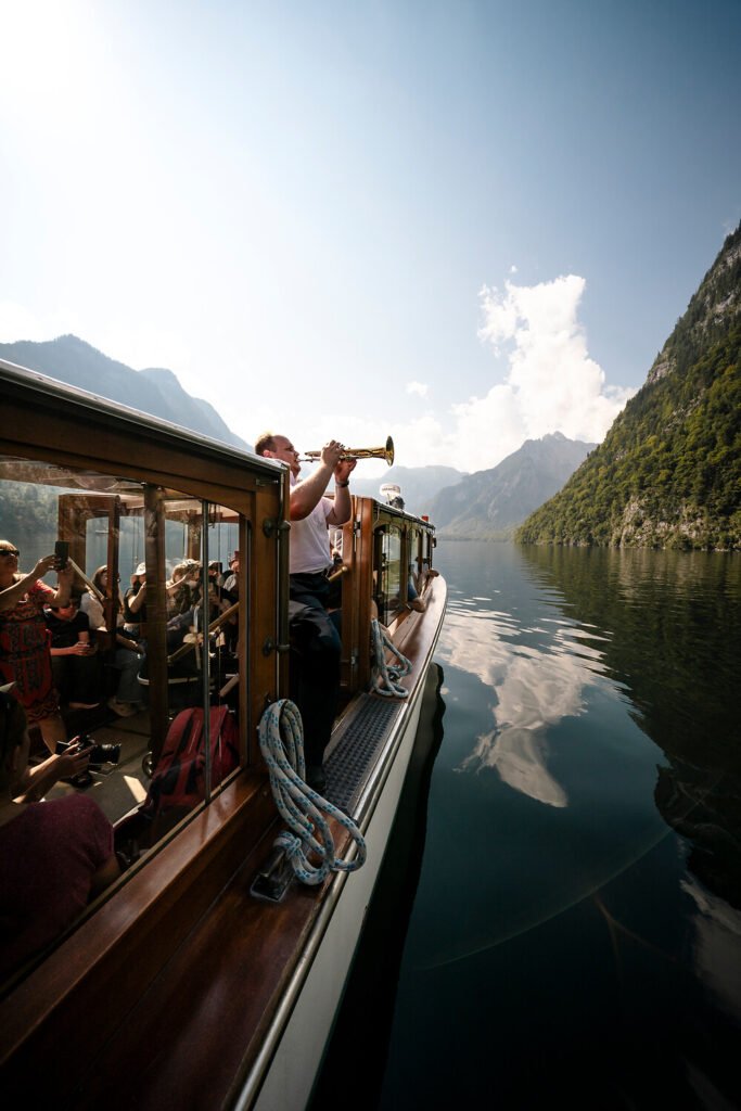 Musician performing on Königssee boat tour with mountain view, Bavaria, Germany